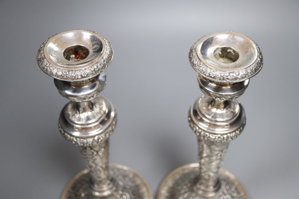 A pair of late George III silver candlesticks, with later embossed decoration, Soloman Hougham, London 1817,